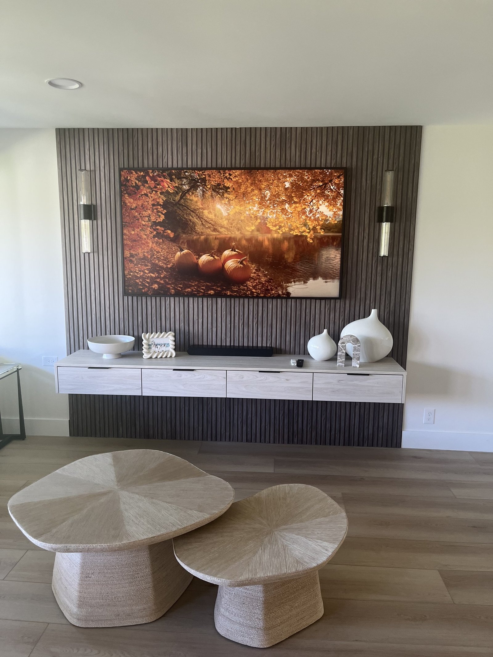 Media wall with vertical slat detail and floating cabinetry