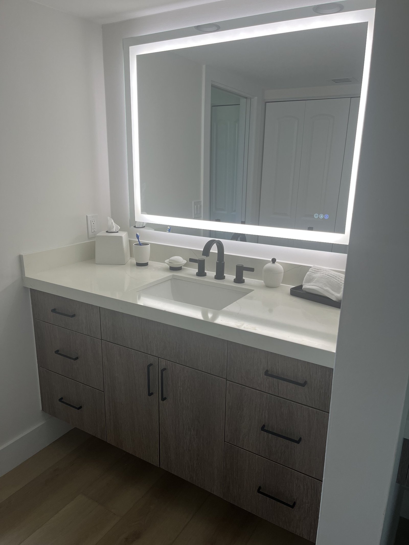 Bathroom vanity with illuminated rectangular mirror
